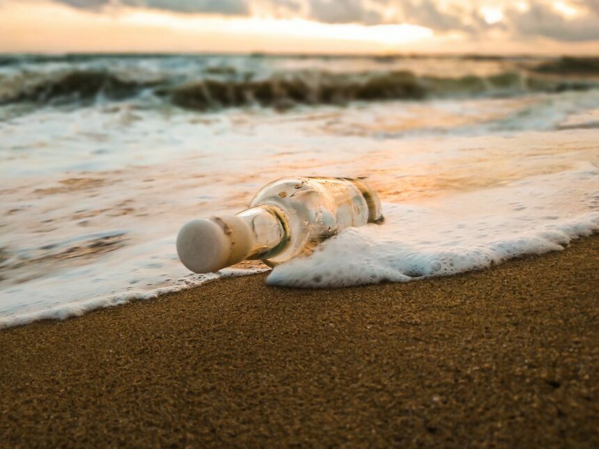 glass bottle on empty sandy beach